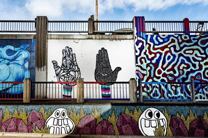 Untitled (collection of three murals: black and white hands facing up, red and blue organic lines, silly faces below) 