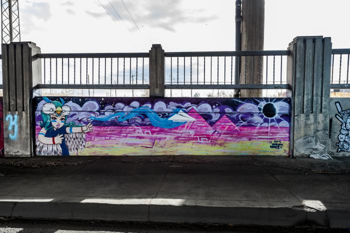 Untitled (girl in front of pink pyramids with paper airplane)